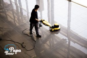 After builders cleaner cleaning a floor with professional machine